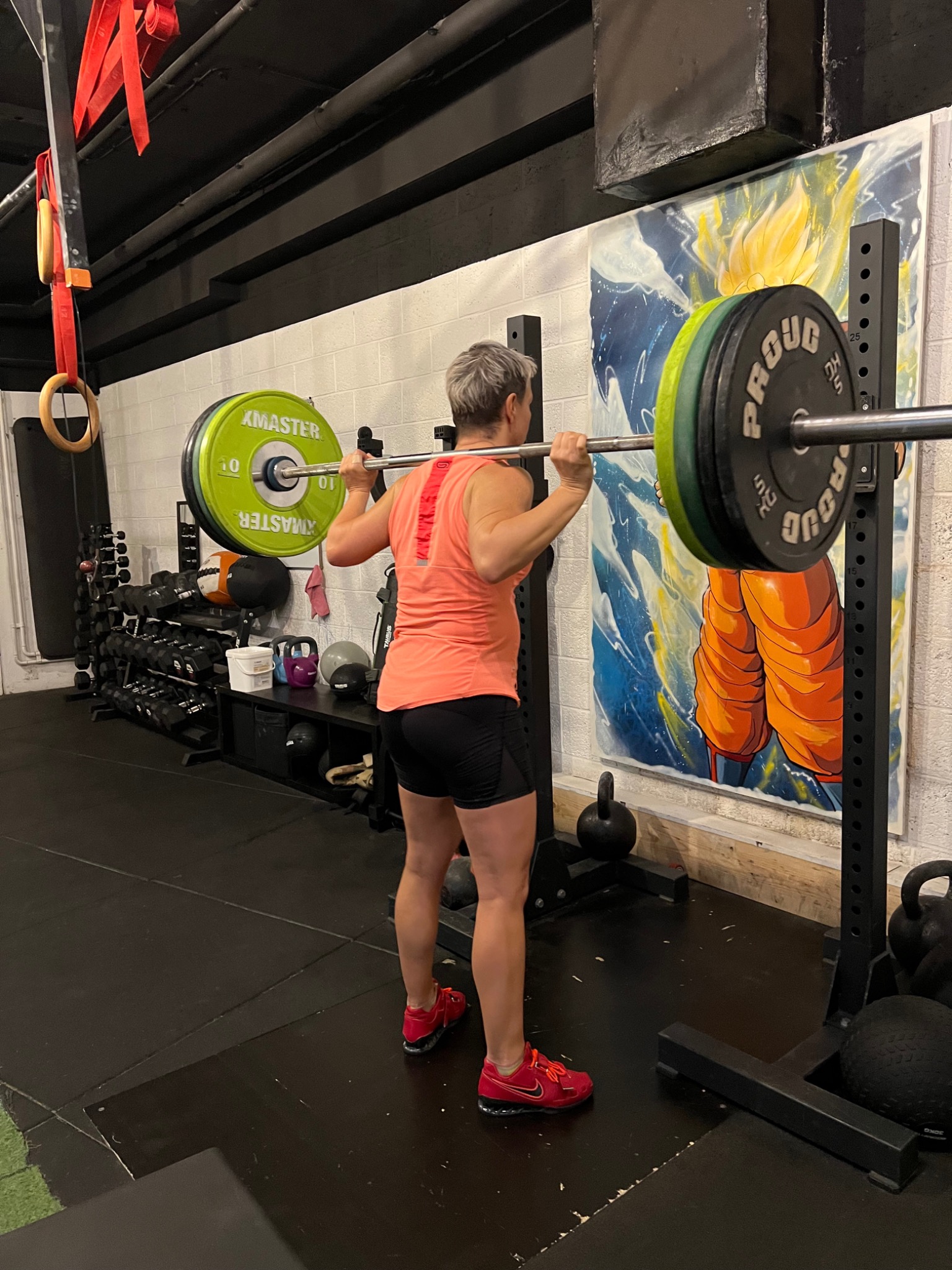 A client practising a barbell squat at Numidia